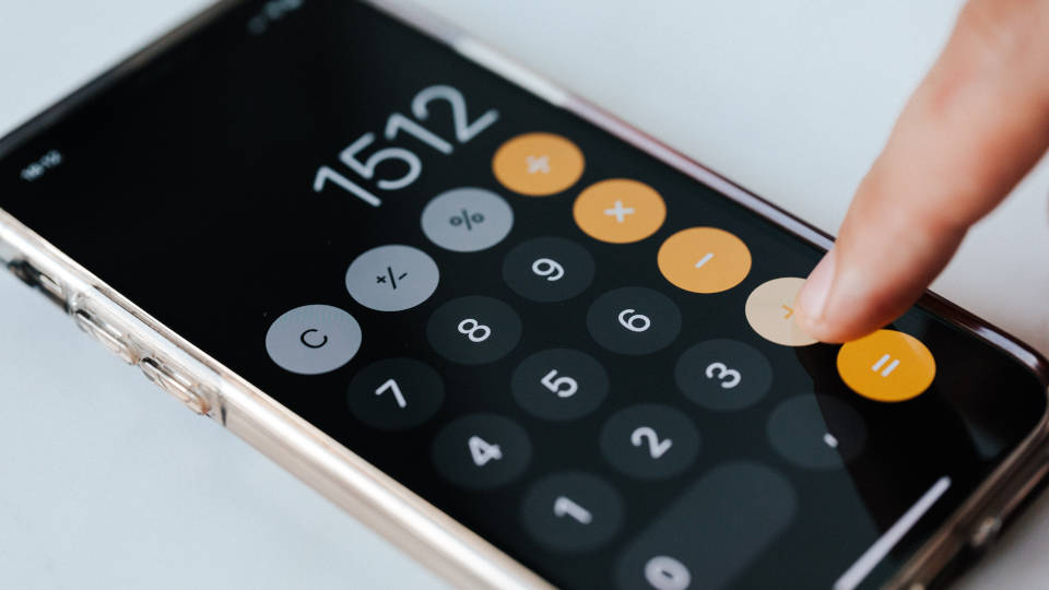 A picture of a lady's hand using an iPhone calculator app.