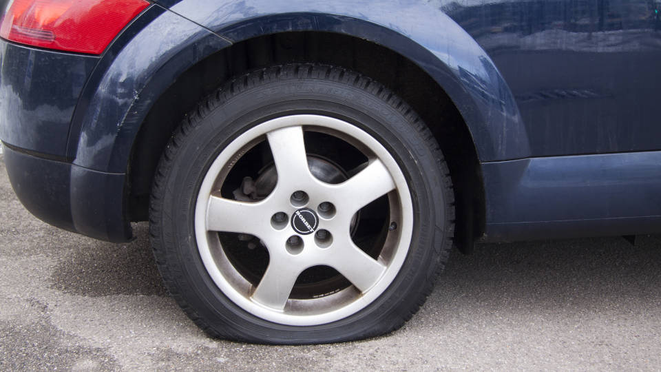 A picture showing a car with a flat tire.