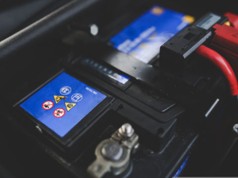 A picture of the car hood open, displaying a brand new car battery.