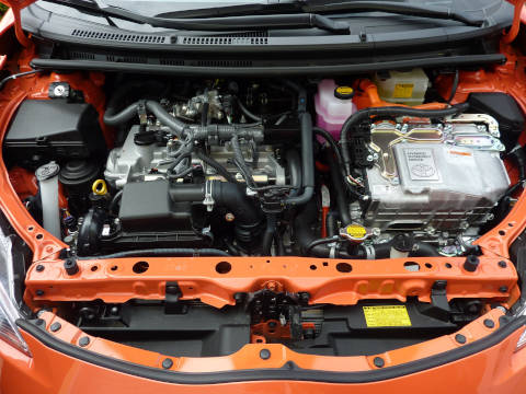 A picture of a the hood of a Hybrid Toyota car open, exposing the engine compartment.